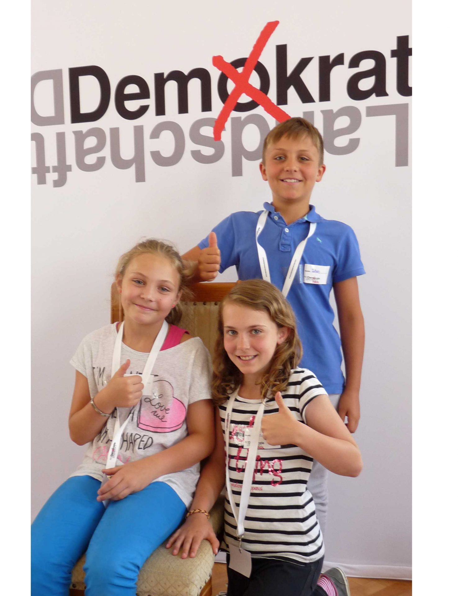 Drei Repoter:innen der Demokratielandschaft Tirol für großem Logo des Projekts